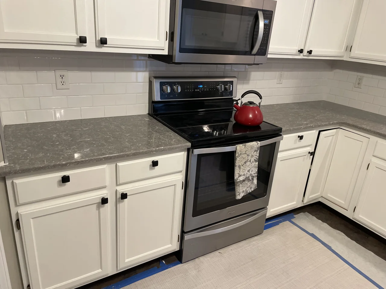 Close-up of white cabinetry and the kitchen tile backsplash